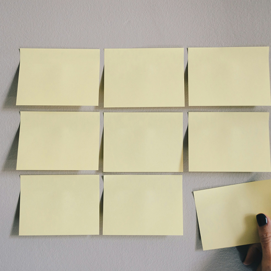 A wall with nine yellow post-it notes, symbolizing steps or an organized process.